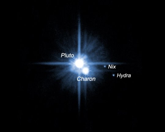 A Pluto és holdjai a HST felvételén.<br />
[NASA, ESA, H. Weaver (JHU/APL), A. Stern (SwRI), HST Pluto Companion Search Team]