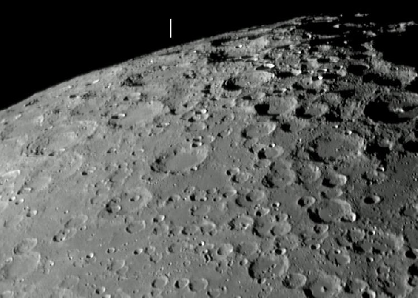 A nehezen észlelhető Hédervári-kráter a Hold déli pólusa közelében. Az alakzatot fehér pálcika jelöli. 